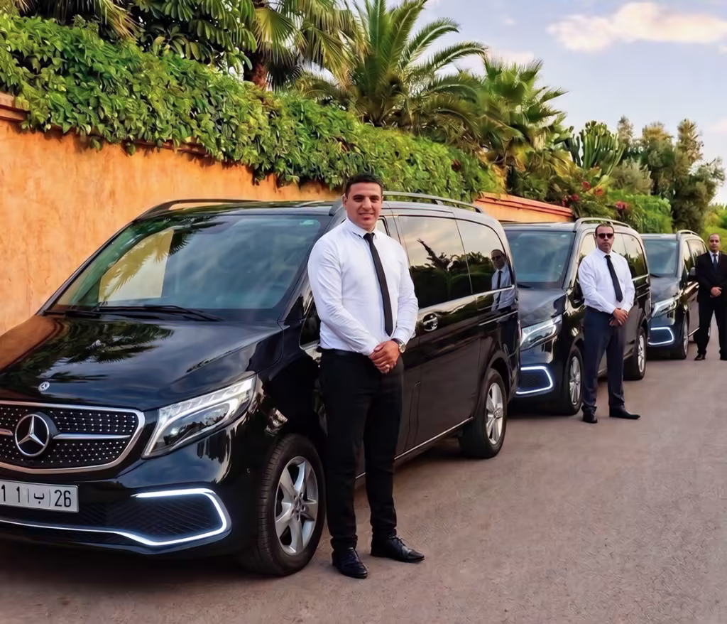 Alignement de minivans Mercedes de luxe noirs et chauffeurs privés professionnels en costume debout