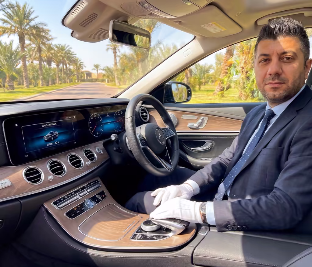 Chauffeur privé professionnel en gants blancs assis au volant de l'habitacle luxueux d'une Mercedes de prestige à Larache