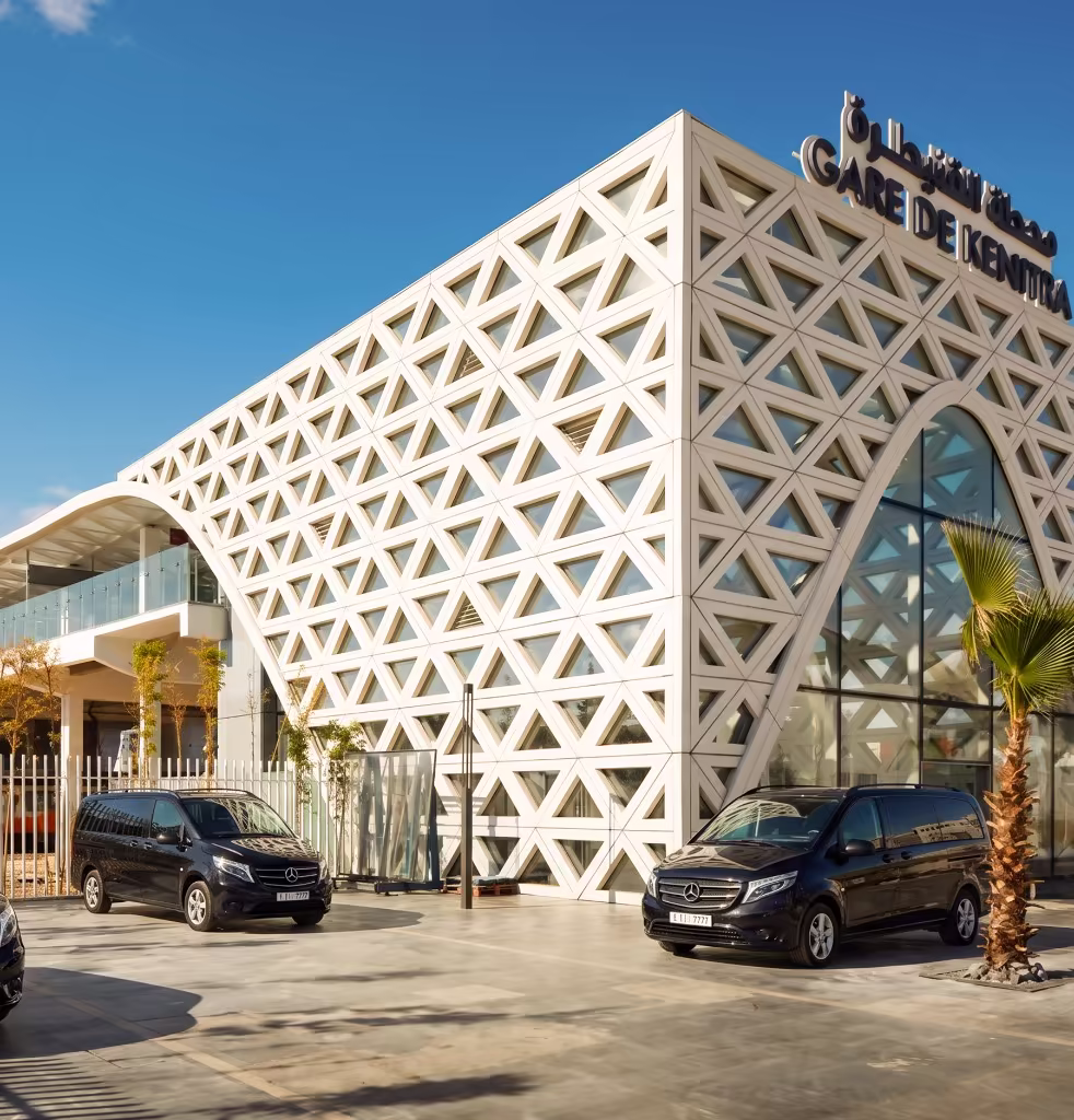 Chauffeur privé professionnel en costume accueillant un client d'affaires à Kénitra