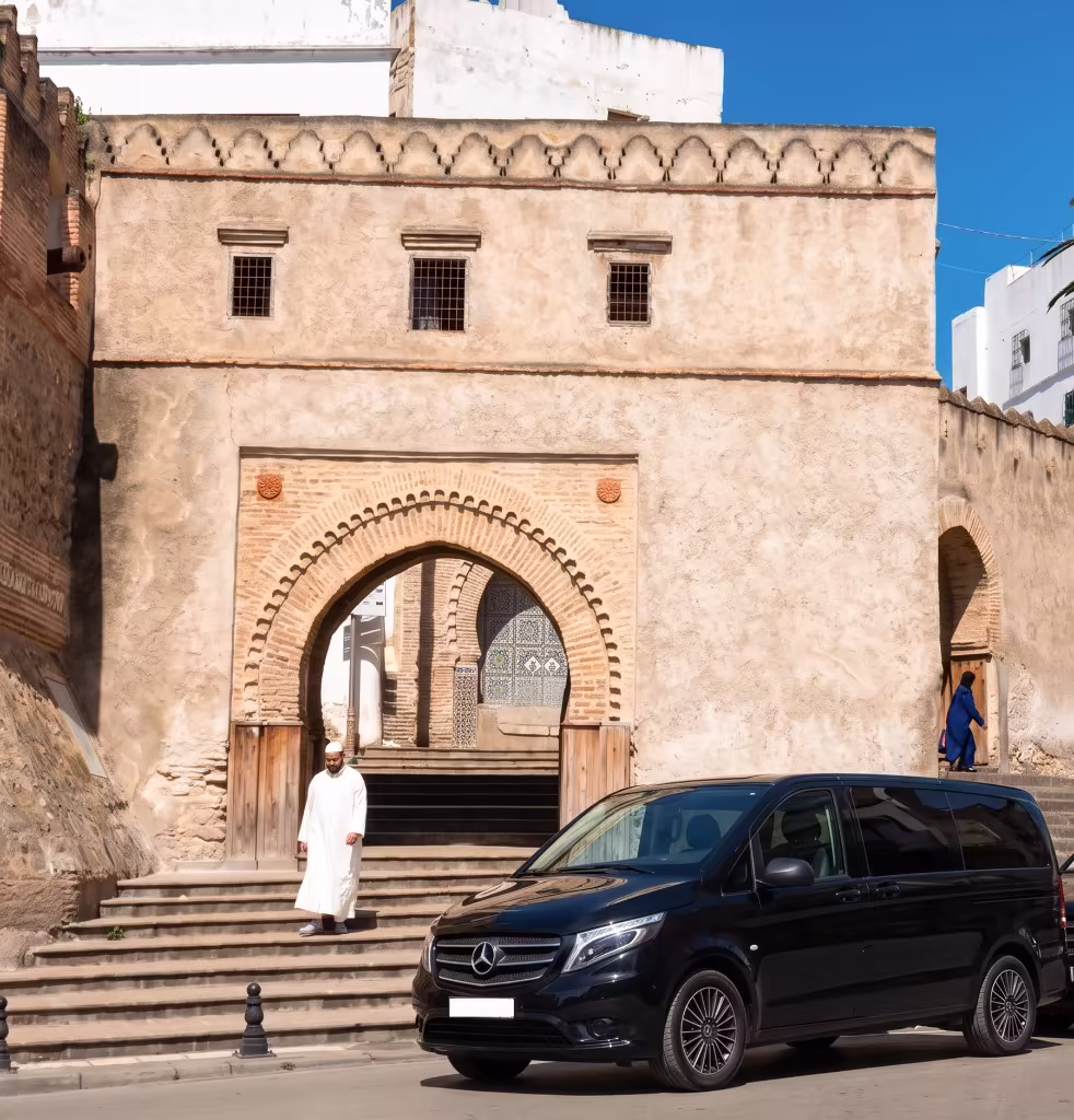 Berline noire avec chauffeur privé devant les arcades hispano-mauresques de Tétouan